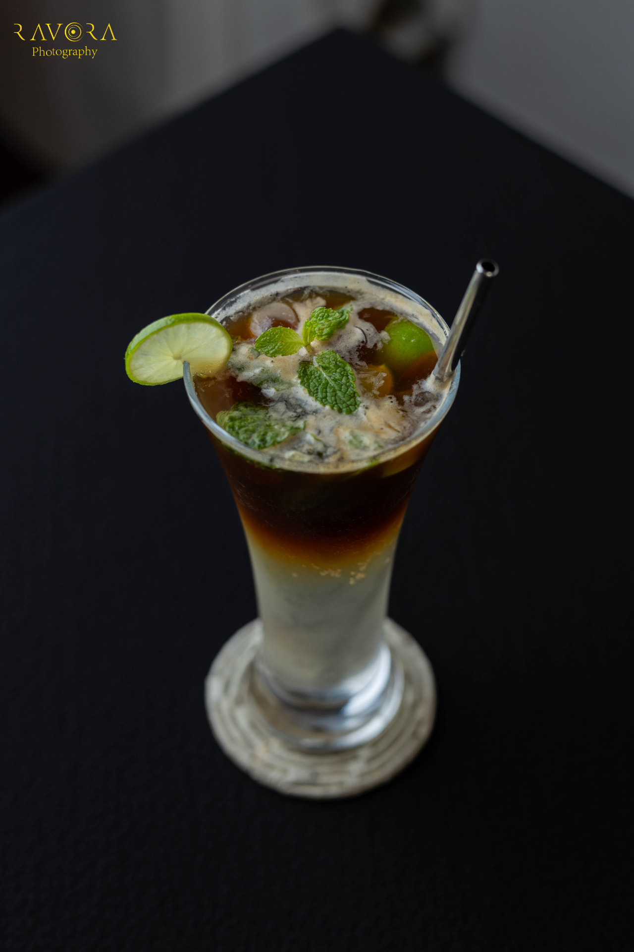Iced coffee with lime and fresh mint on a dark table